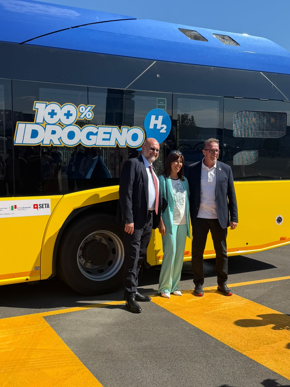 Tre partecipanti all’inaugurazione davanti a un autobus SETA a idrogeno